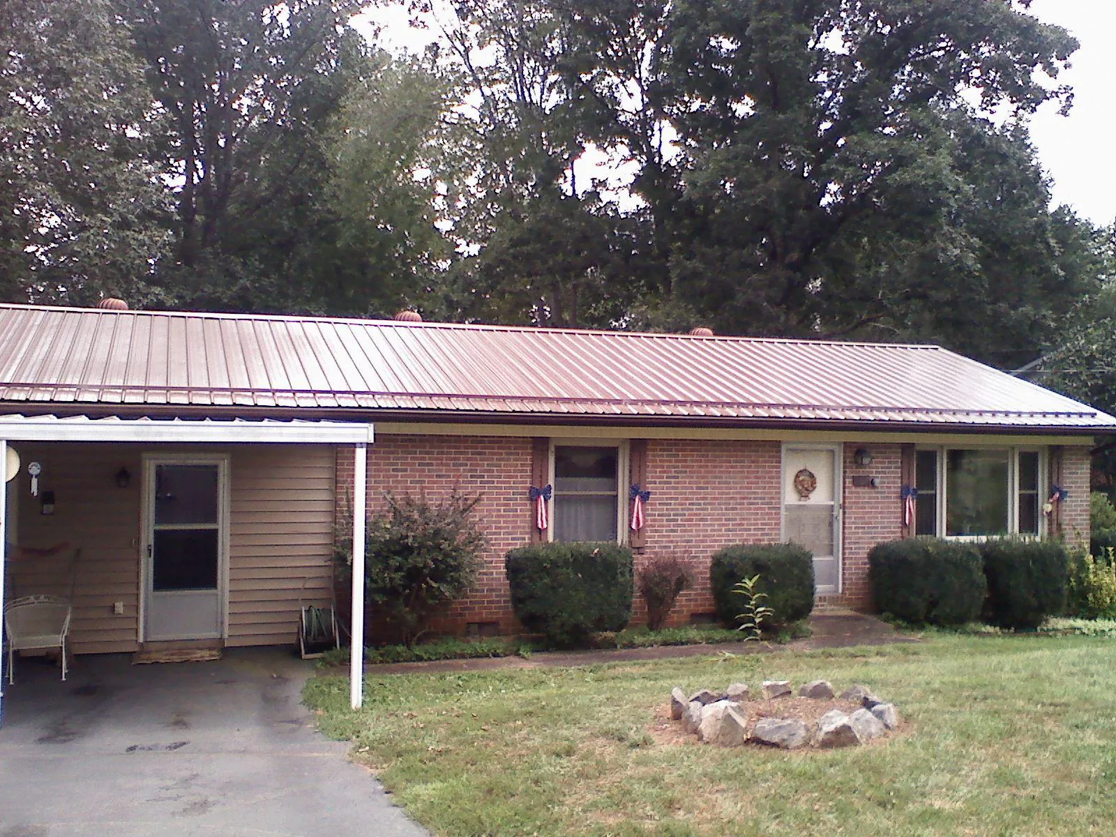 Bronze metal roof and carport on a brick ranch home — Roof Repair work by our crew in Weston